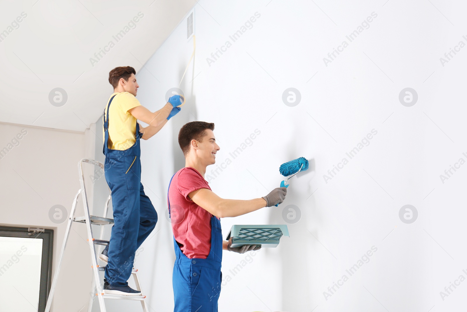 Male decorators refurbishing empty room Photo of Male decorators refurbishing empty room