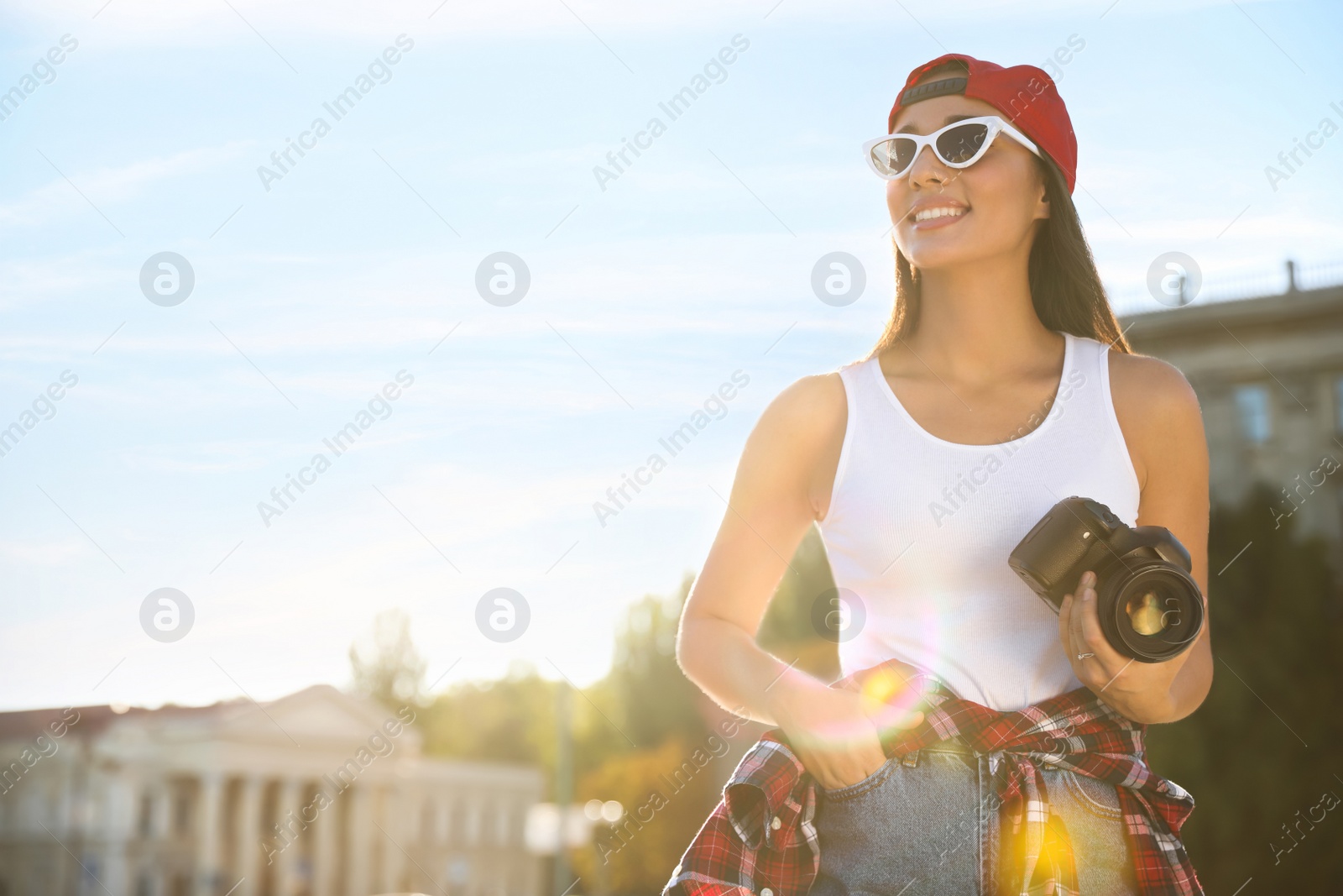 Young photographer with professional camera outdoors. Space for text Photo of Young photographer with professional camera outdoors. Space for text