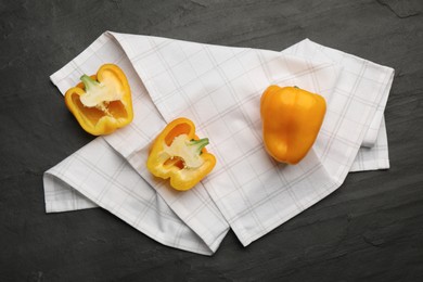 Kitchen towel with bell peppers on black table, flat lay Photo of Kitchen towel with bell peppers on black table, flat lay