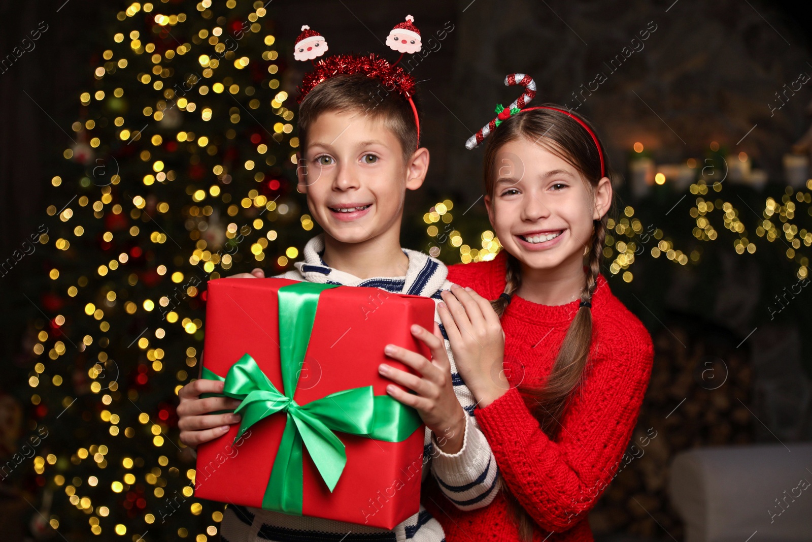 Portrait of happy children with Christmas gift at home Photo of Portrait of happy children with Christmas gift at home