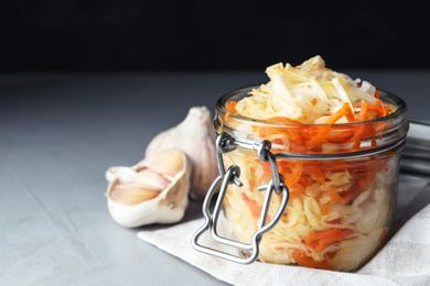 Tasty fermented cabbage with carrot on light grey table, closeup Photo of Tasty fermented cabbage with carrot on light grey table, closeup