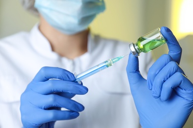 Doctor filling syringe with medication in clinic, closeup. Vaccination and immunization Photo of Doctor filling syringe with medication in clinic, closeup. Vaccination and immunization