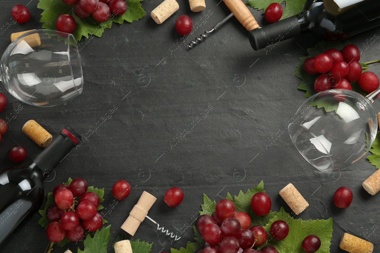 Frame of tasty red wine and grapes on black table, flat lay. Space for text Photo of Frame of tasty red wine and grapes on black table, flat lay. Space for text