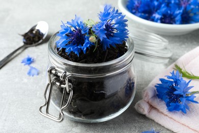 Dry tea leaves and cornflowers on light table, closeup Photo of Dry tea leaves and cornflowers on light table, closeup