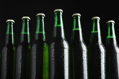 Bottles of beer on black background, closeup Photo of Bottles of beer on black background, closeup