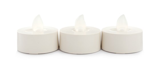 Decorative flameless LED candles on white background Photo of Decorative flameless LED candles on white background