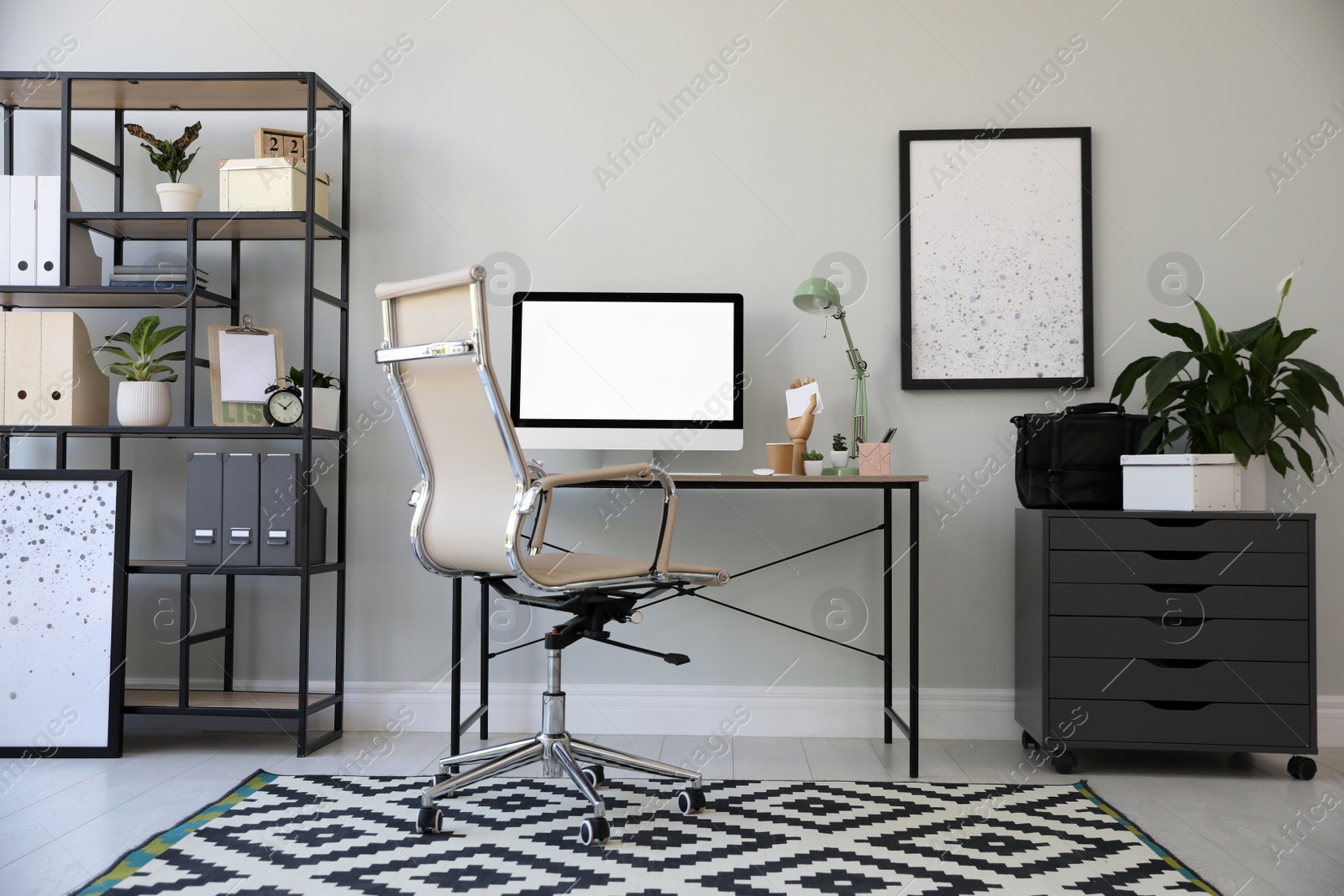 Comfortable office chair near desk with modern computer indoors Photo of Comfortable office chair near desk with modern computer indoors