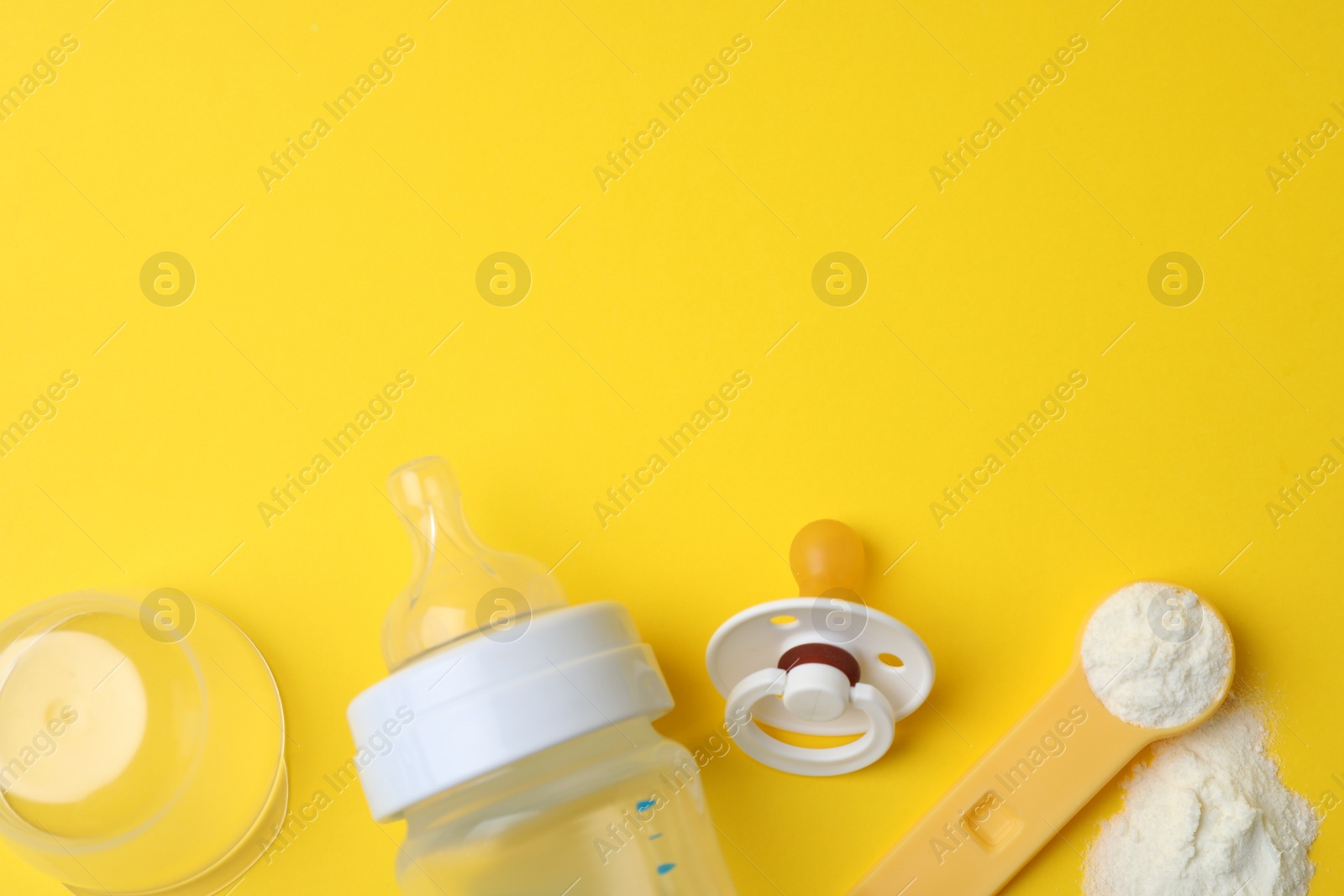 Flat lay composition with powdered infant formula on yellow background, space for text. Baby milk Photo of Flat lay composition with powdered infant formula on yellow background, space for text. Baby milk
