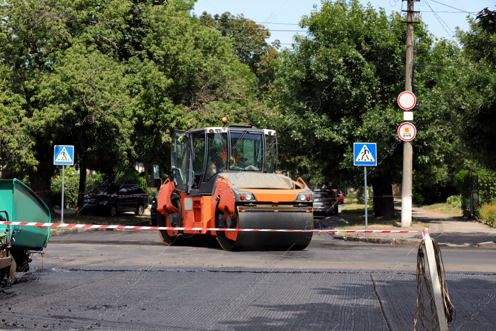 Roller working on city street. Road repairing Photo of Roller working on city street. Road repairing
