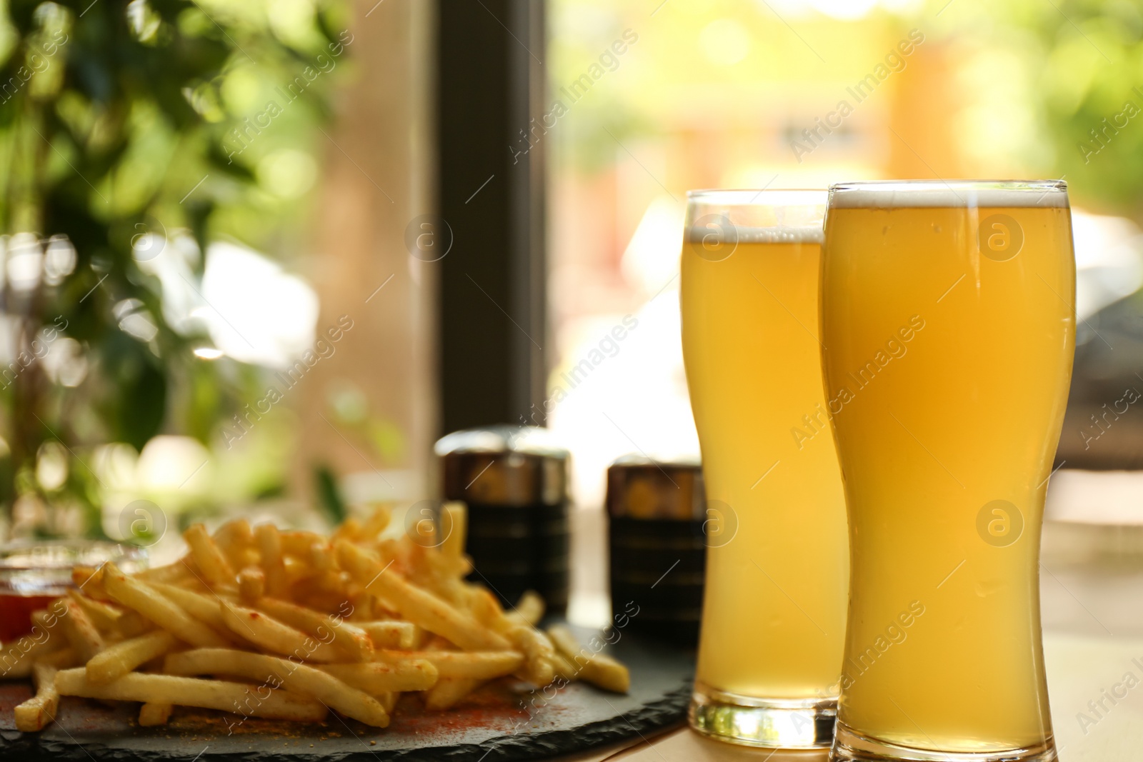 Delicious hot french fries and beer served on table Photo of Delicious hot french fries and beer served on table