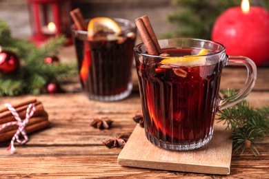 Aromatic mulled wine on wooden table, space for text Photo of Aromatic mulled wine on wooden table, space for text