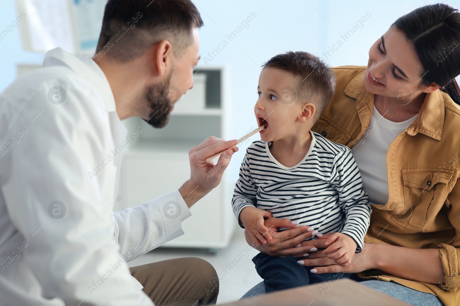 Mother and son visiting pediatrician in hospital. Doctor examining little boy Photo of Mother and son visiting pediatrician in hospital. Doctor examining little boy