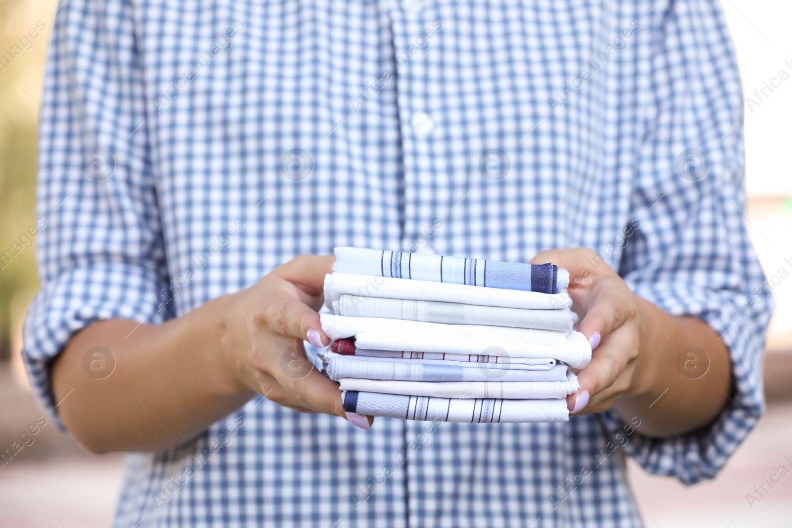 Photo of Woman holding many different handkerchiefs outdoors, closeup