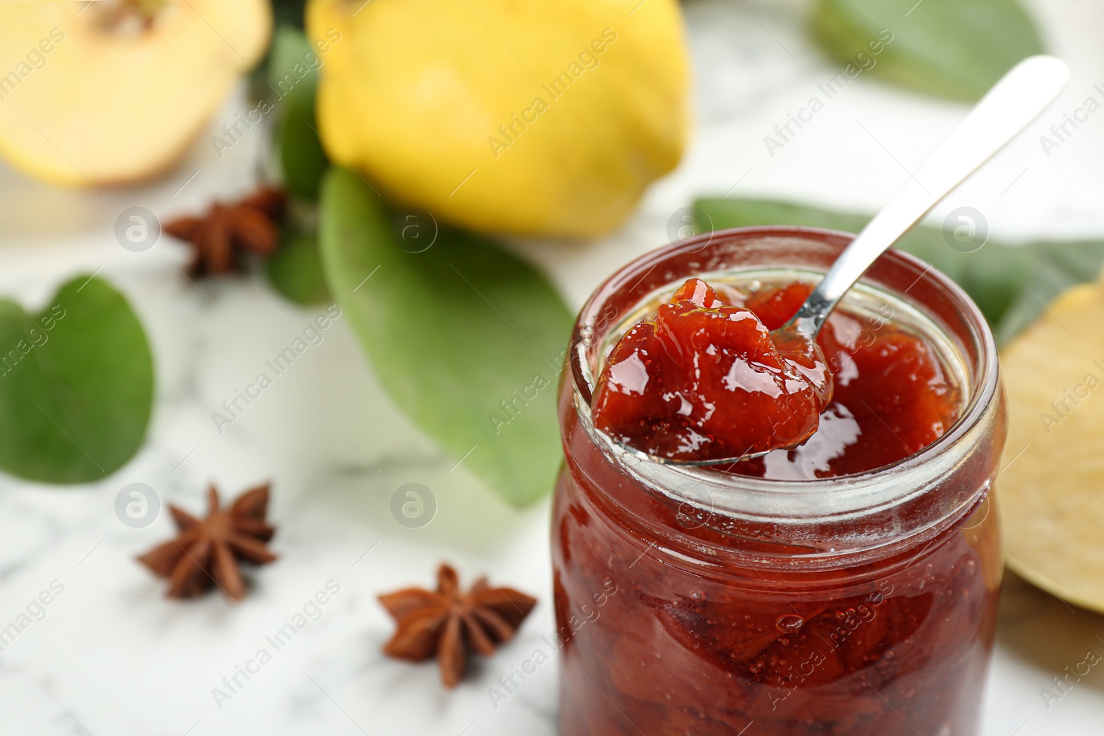 Delicious quince jam on light table, closeup Photo of Delicious quince jam on light table, closeup