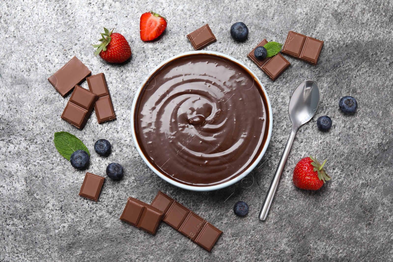 Delicious chocolate cream with berries and mint on grey table, flat lay Photo of Delicious chocolate cream with berries and mint on grey table, flat lay