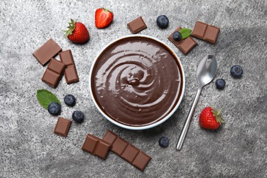 Delicious chocolate cream with berries and mint on grey table, flat lay Photo of Delicious chocolate cream with berries and mint on grey table, flat lay