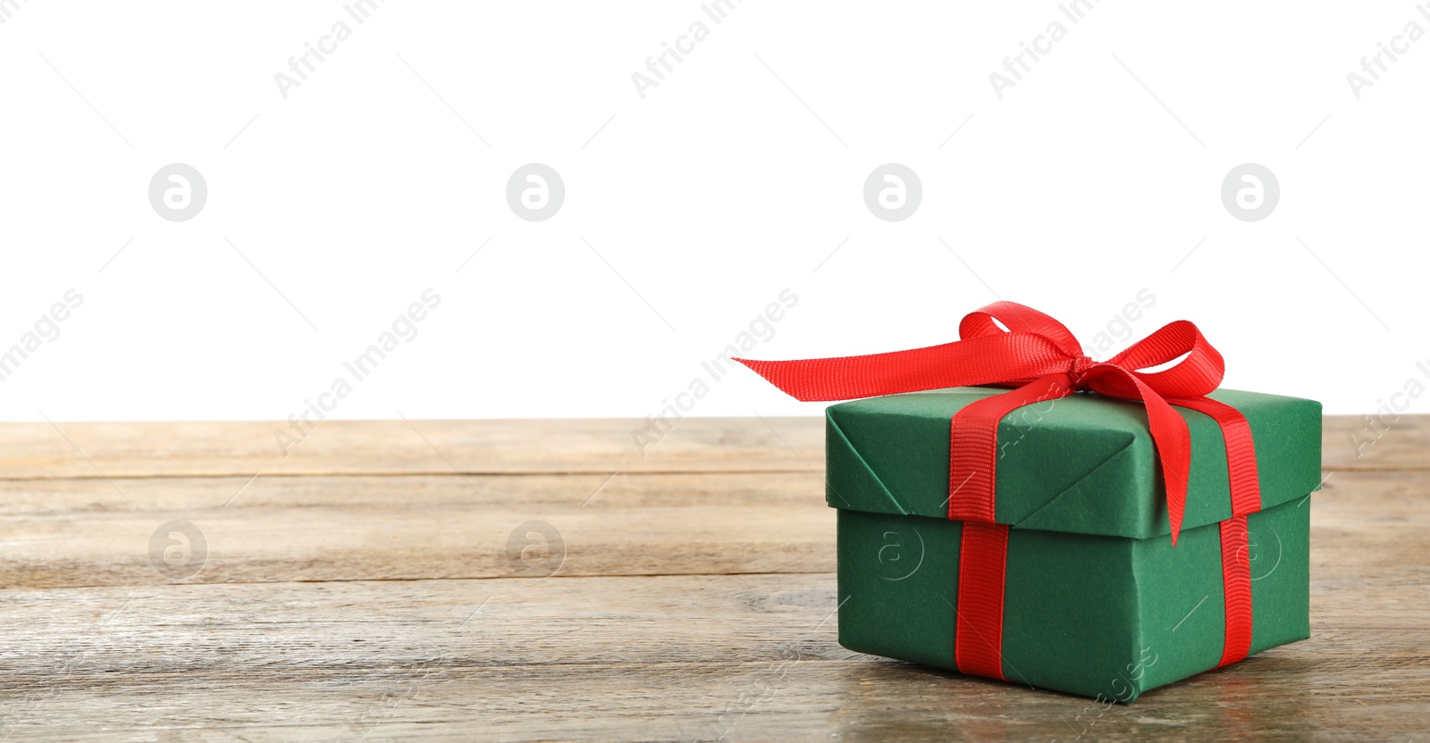 Christmas gift on wooden table against white background. Space for text Photo of Christmas gift on wooden table against white background. Space for text