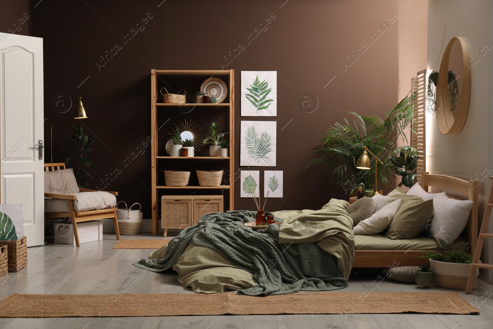 Stylish interior with large comfortable bed and potted plants Photo of Stylish interior with large comfortable bed and potted plants