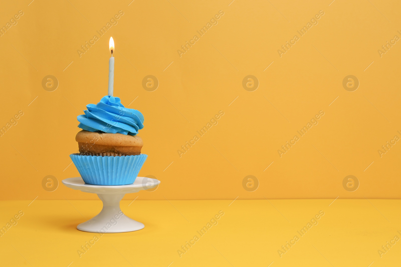 Birthday cupcake with candle on color background Photo of Birthday cupcake with candle on color background