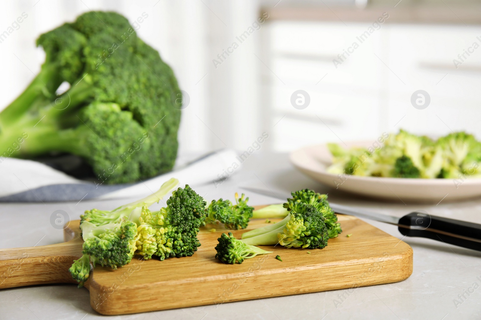 Raw green broccoli on light grey marble table Photo of Raw green broccoli on light grey marble table