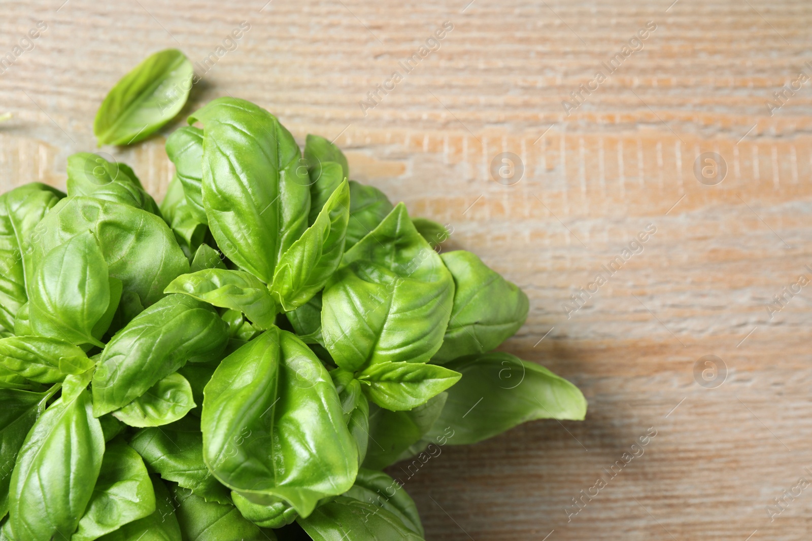 Fresh basil on wooden table, top view. Space for text Photo of Fresh basil on wooden table, top view. Space for text