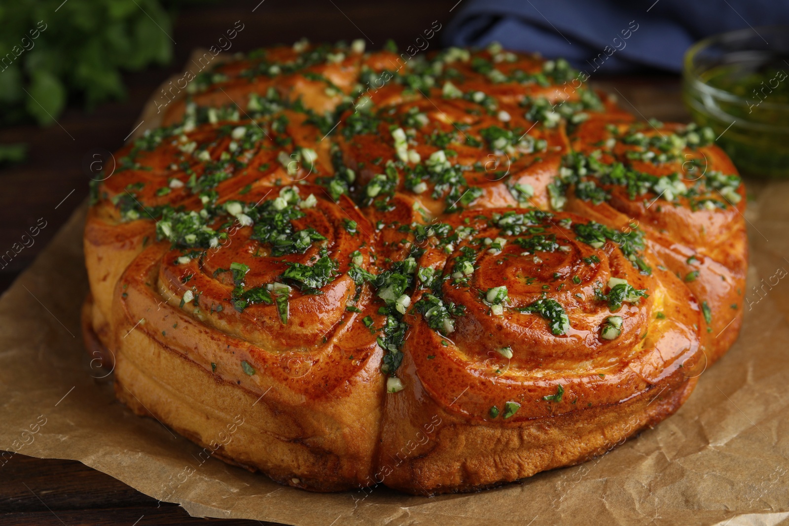 Traditional Ukrainian garlic bread with herbs (Pampushky) on wooden table, closeup Photo of Traditional Ukrainian garlic bread with herbs (Pampushky) on wooden table, closeup