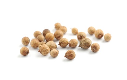 Scattered dried coriander seeds on white background Photo of Scattered dried coriander seeds on white background