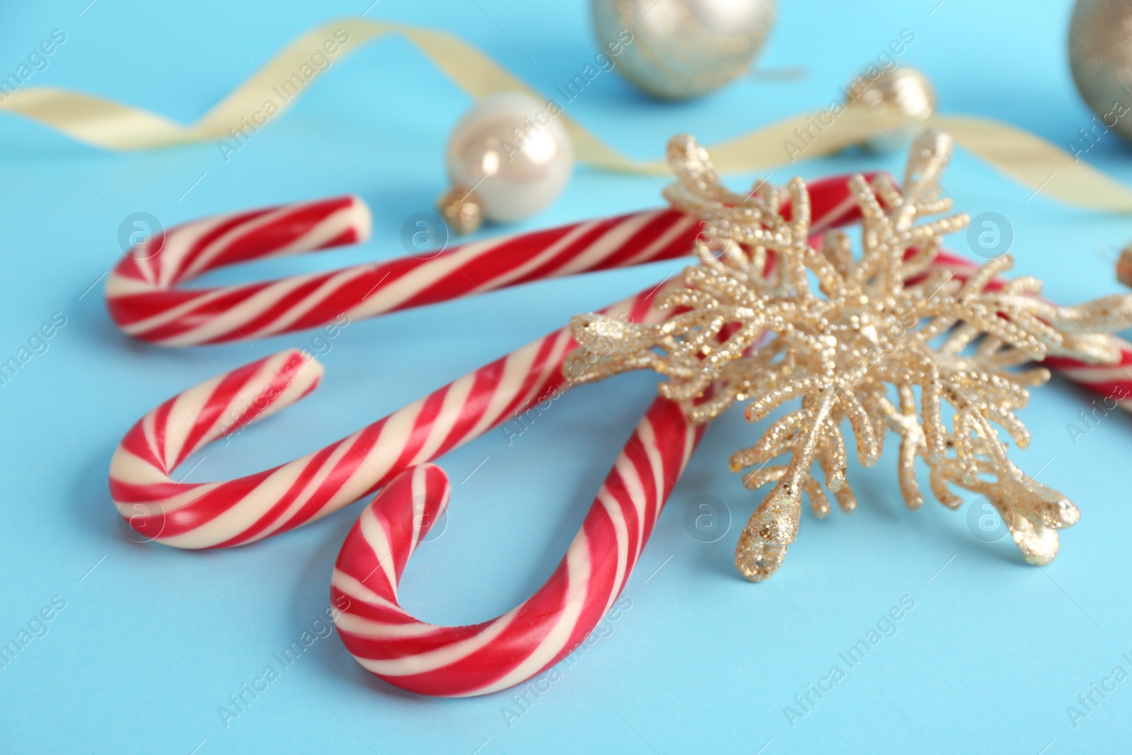 Christmas candy canes and decorative snowflake on light blue background, closeup Photo of Christmas candy canes and decorative snowflake on light blue background, closeup