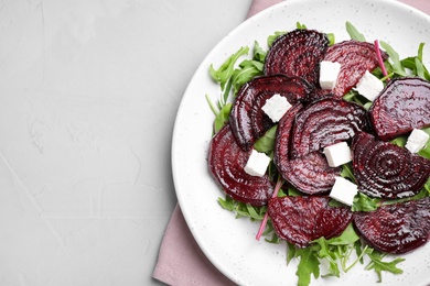 Roasted beetroot slices with feta cheese and arugula on light grey table, top view. Space for text Photo of Roasted beetroot slices with feta cheese and arugula on light grey table, top view. Space for text