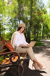 Beautiful woman working with laptop in park Photo of Beautiful woman working with laptop in park