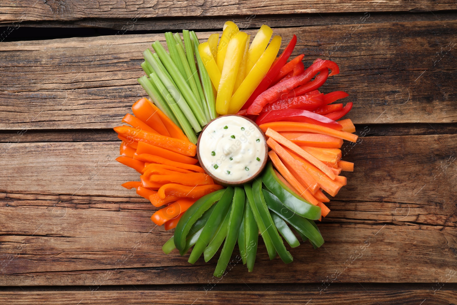 Different vegetables cut in sticks and dip sauce on wooden table, top view Photo of Different vegetables cut in sticks and dip sauce on wooden table, top view