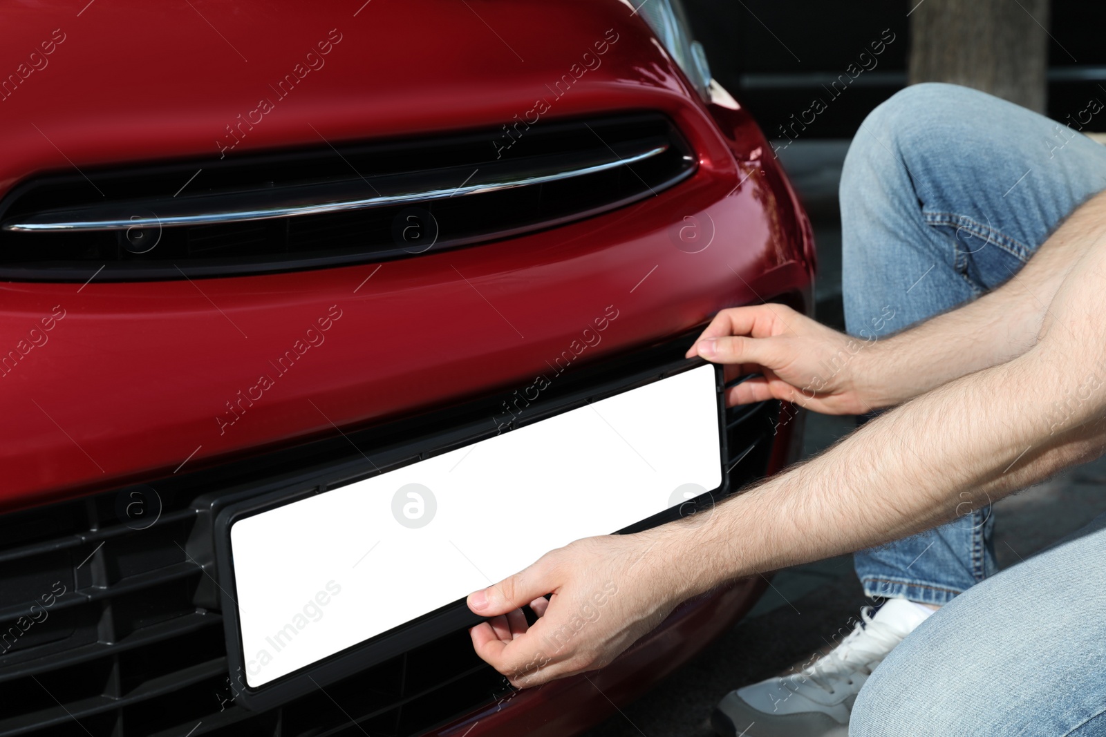 Man installing vehicle registration plate outdoors, closeup. Mockup for design Photo of Man installing vehicle registration plate outdoors, closeup. Mockup for design
