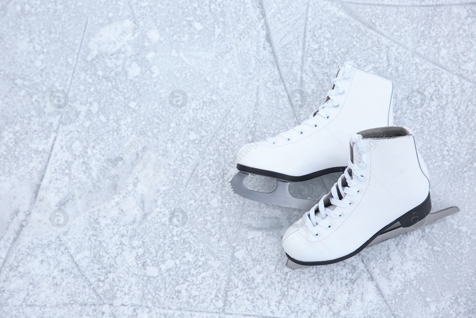 Pair of figure skates on ice, top view with space for text. Winter outdoors activities Photo of Pair of figure skates on ice, top view with space for text. Winter outdoors activities
