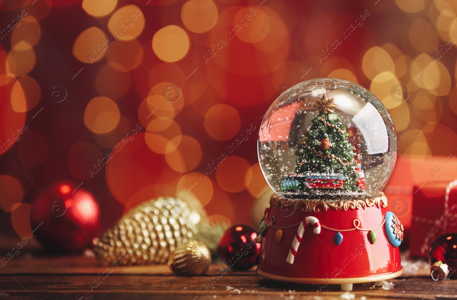 Beautiful snow globe with Christmas tree on wooden table against blurred festive lights. Space for text Photo of Beautiful snow globe with Christmas tree on wooden table against blurred festive lights. Space for text