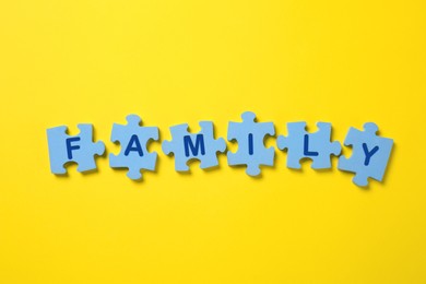 Word Family made of puzzles with letters on yellow background, flat lay Photo of Word Family made of puzzles with letters on yellow background, flat lay