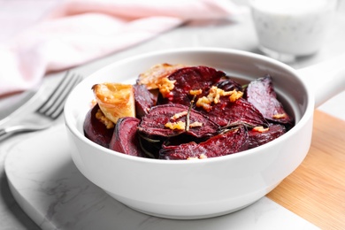 Bowl with roasted beetroot slices, garlic and rosemary on board, closeup Photo of Bowl with roasted beetroot slices, garlic and rosemary on board, closeup