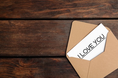Card with phrase I Love You in envelope on wooden table, top view. Space for text Photo of Card with phrase I Love You in envelope on wooden table, top view. Space for text