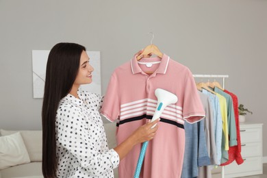 Woman steaming shirt on hanger at home Photo of Woman steaming shirt on hanger at home