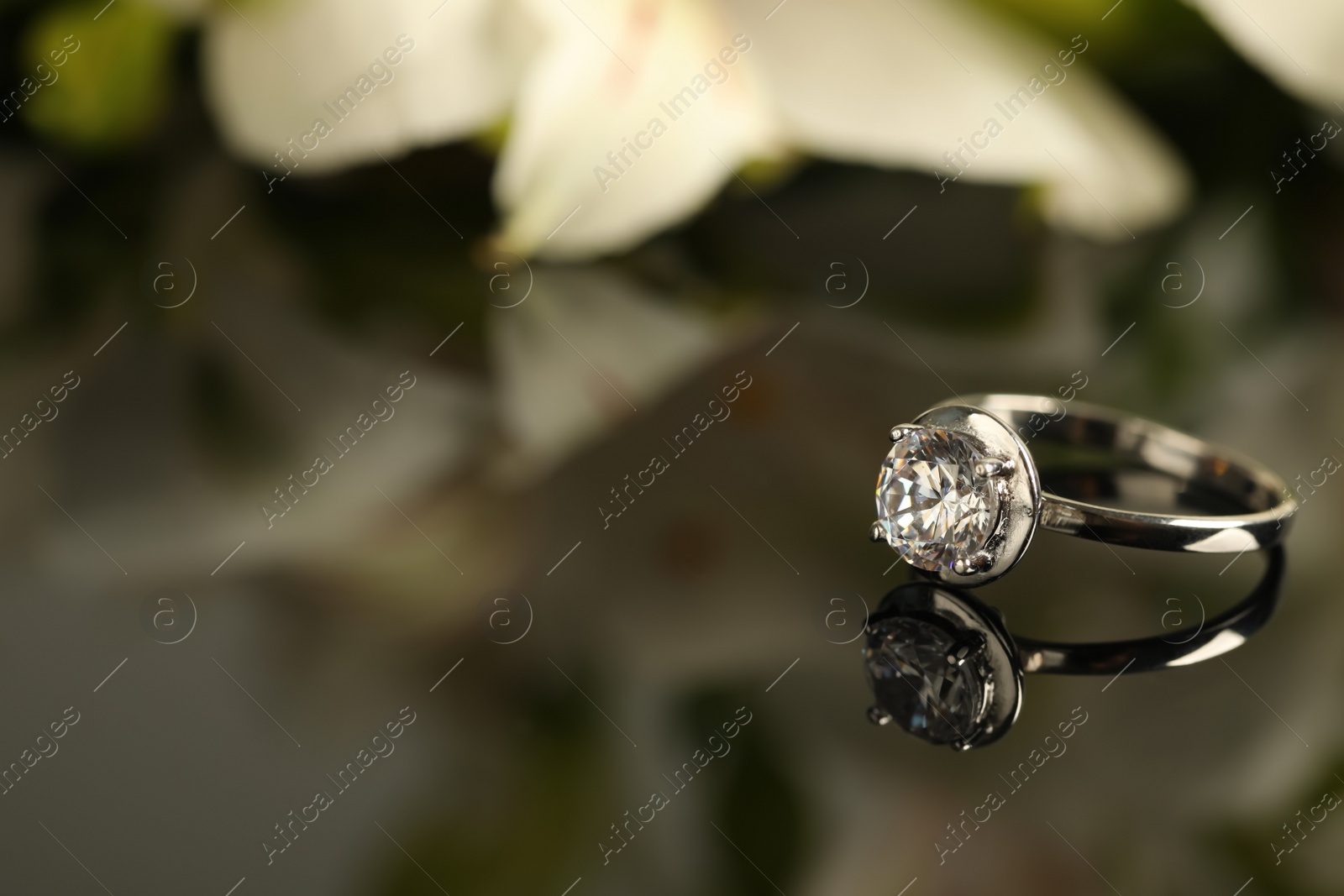 Beautiful engagement ring against blurred background, space for text Photo of Beautiful engagement ring against blurred background, space for text