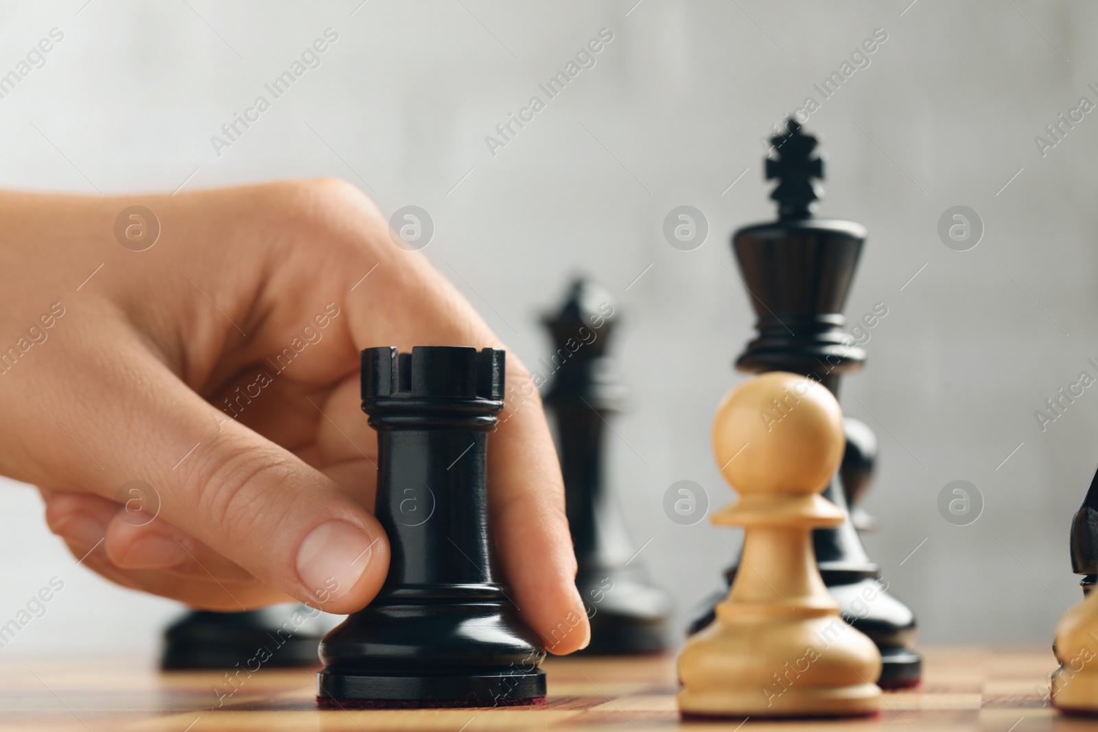 Photo of Woman moving chess piece on board, closeup
