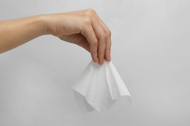 Woman holding paper tissue on light background, closeup Photo of Woman holding paper tissue on light background, closeup