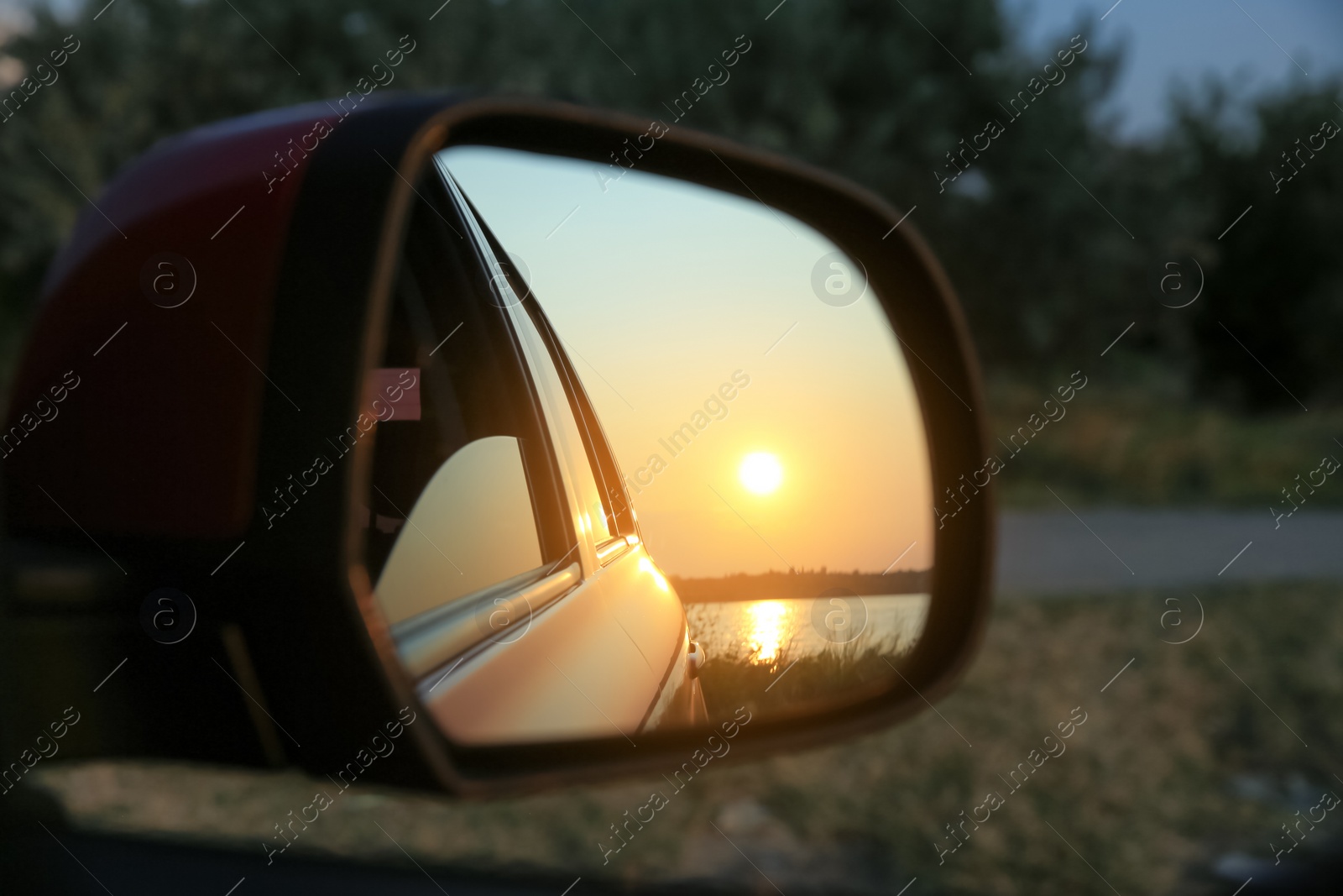 Reflection of landscape with beautiful sunset over calm river in car side view mirror, closeup Photo of Reflection of landscape with beautiful sunset over calm river in car side view mirror, closeup