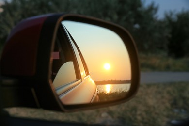 Reflection of landscape with beautiful sunset over calm river in car side view mirror, closeup Photo of Reflection of landscape with beautiful sunset over calm river in car side view mirror, closeup