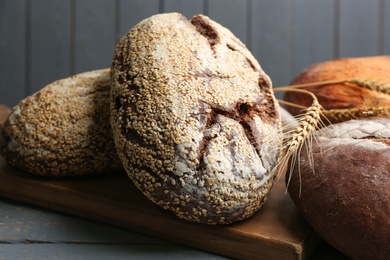 Loaves of delicious fresh bread on grey wooden table, closeup Photo of Loaves of delicious fresh bread on grey wooden table, closeup