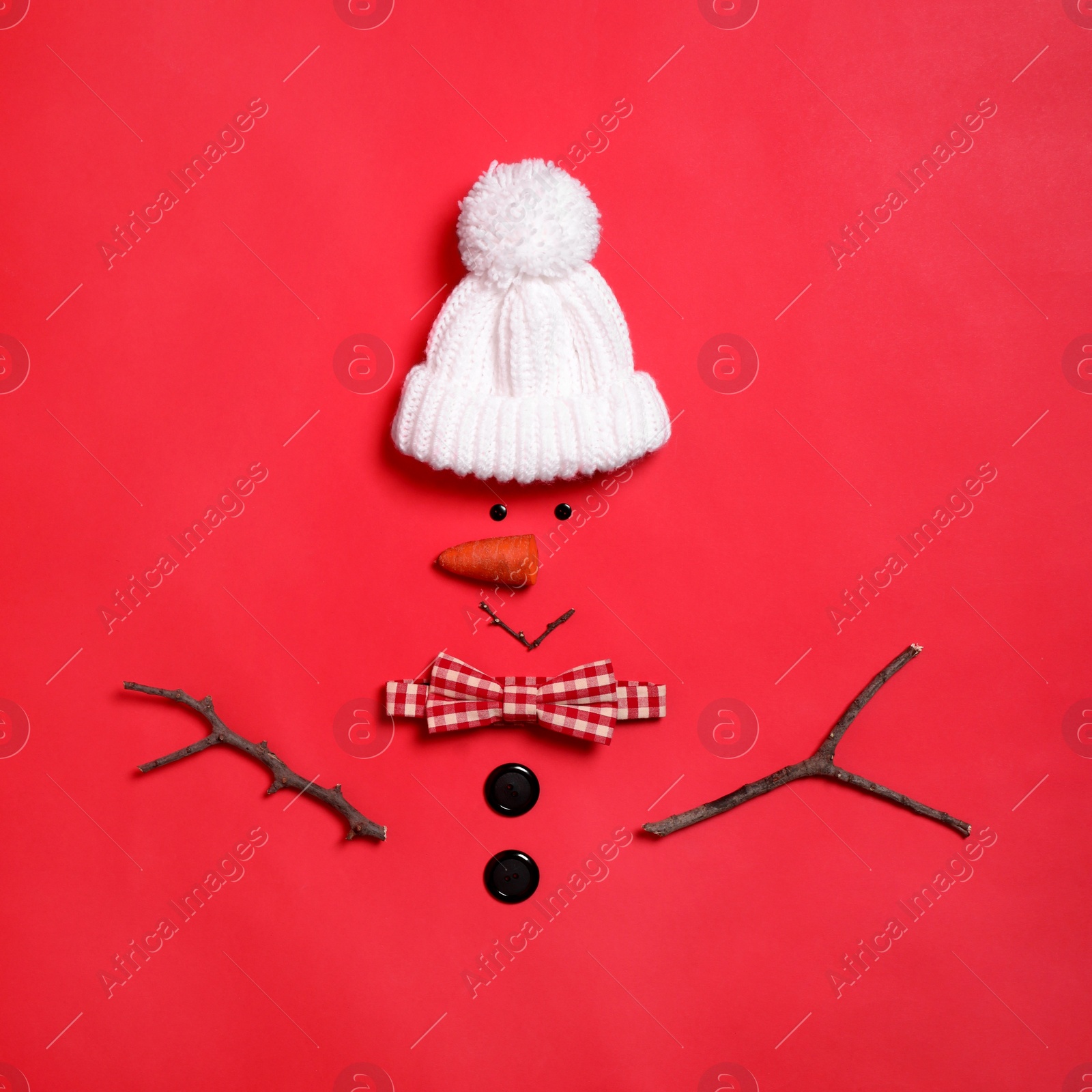 Funny snowman made with different elements on red background, flat lay Photo of Funny snowman made with different elements on red background, flat lay