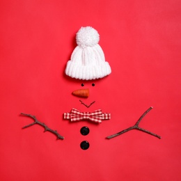 Funny snowman made with different elements on red background, flat lay Photo of Funny snowman made with different elements on red background, flat lay