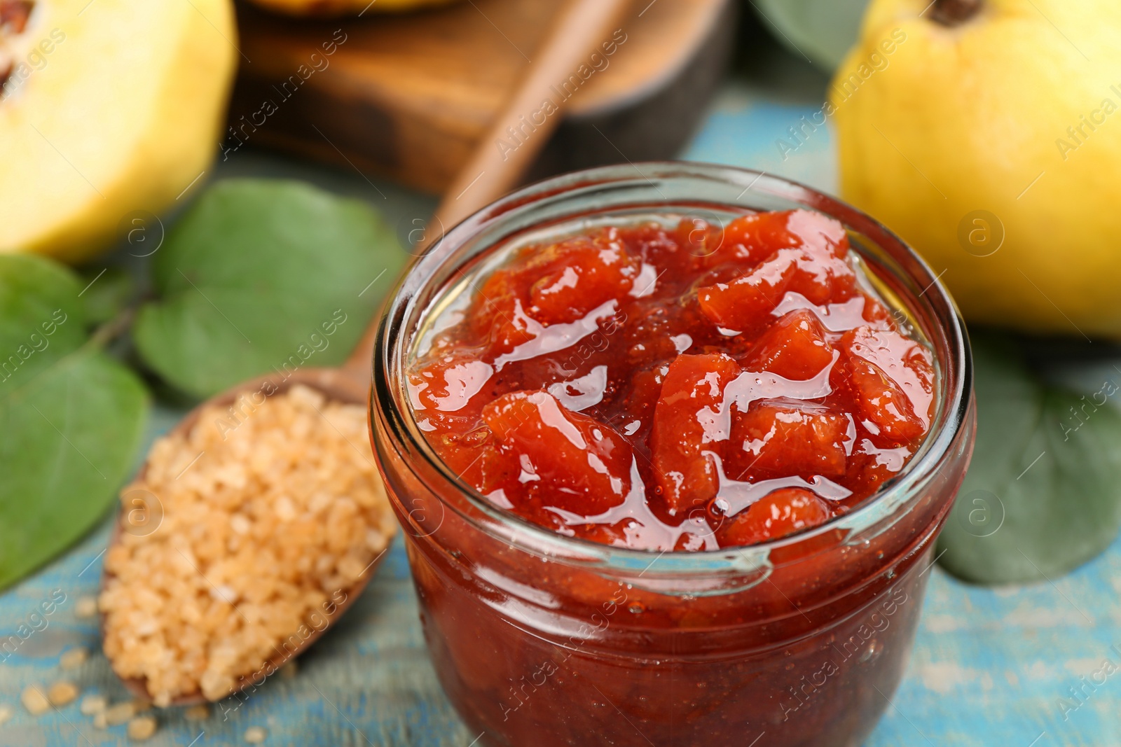 Photo of Delicious quince jam on light blue table, closeup
