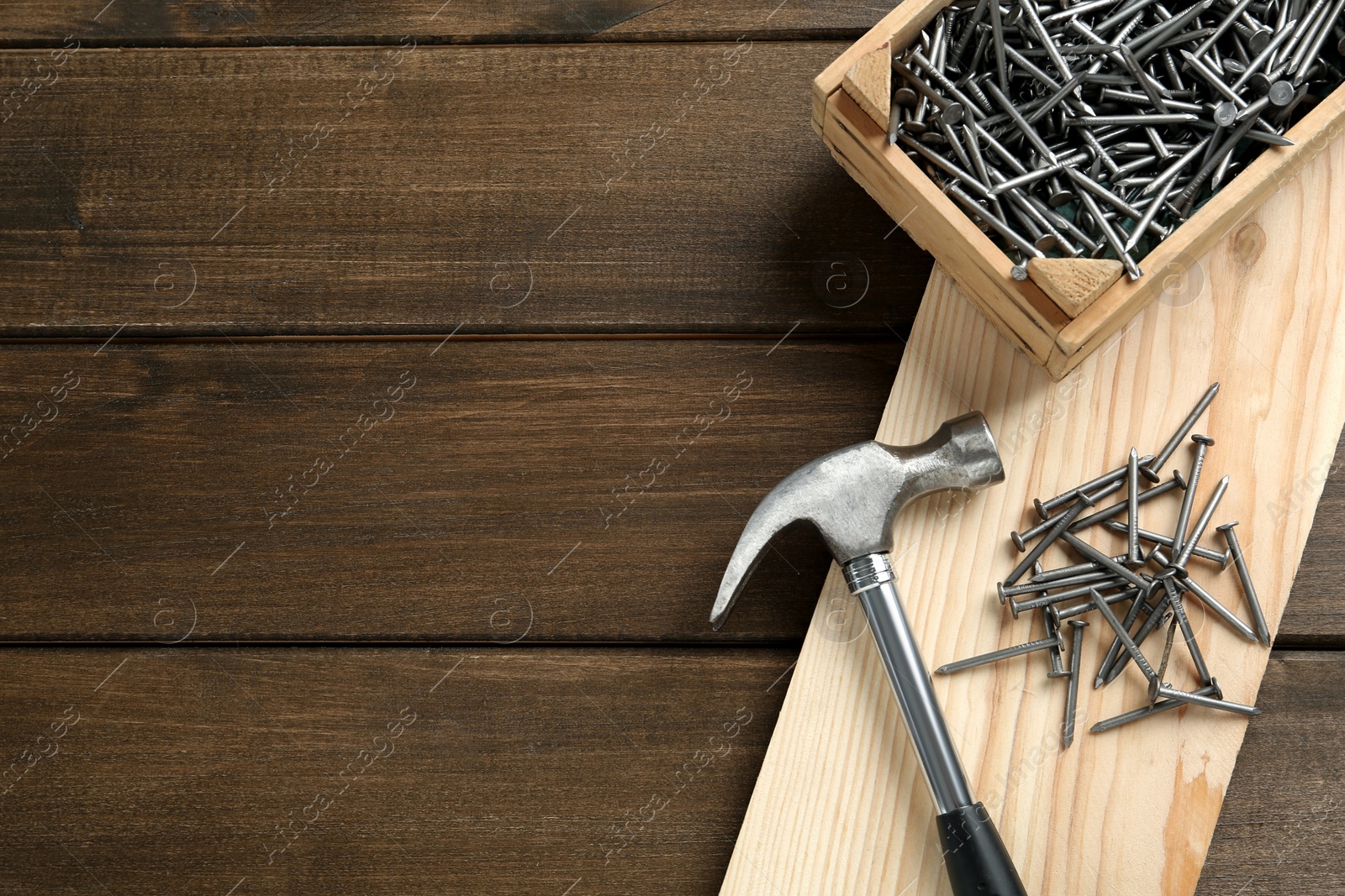 Hammer and metal nails on wooden table, flat lay. Space for text Photo of Hammer and metal nails on wooden table, flat lay. Space for text