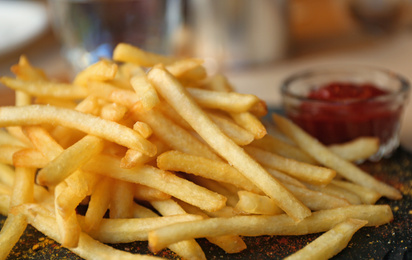 Tasty French fries with red sauce served on table in cafe, closeup Photo of Tasty French fries with red sauce served on table in cafe, closeup
