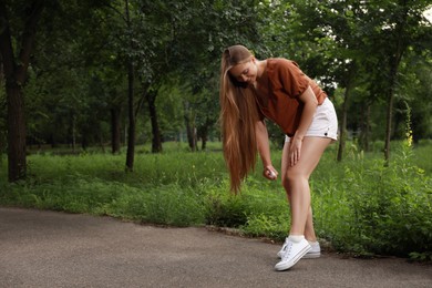 Woman applying insect repellent onto leg in park. Tick bites prevention Photo of Woman applying insect repellent onto leg in park. Tick bites prevention